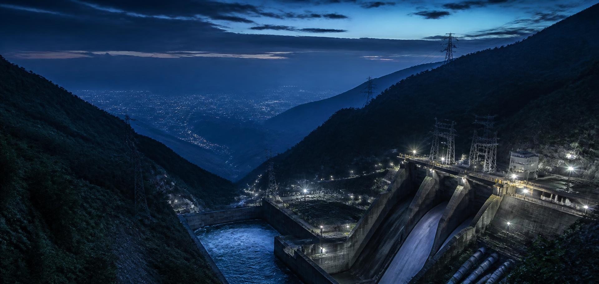Hydropower dam and transmission infrastructure above the Kathmandu valley at blue hour
